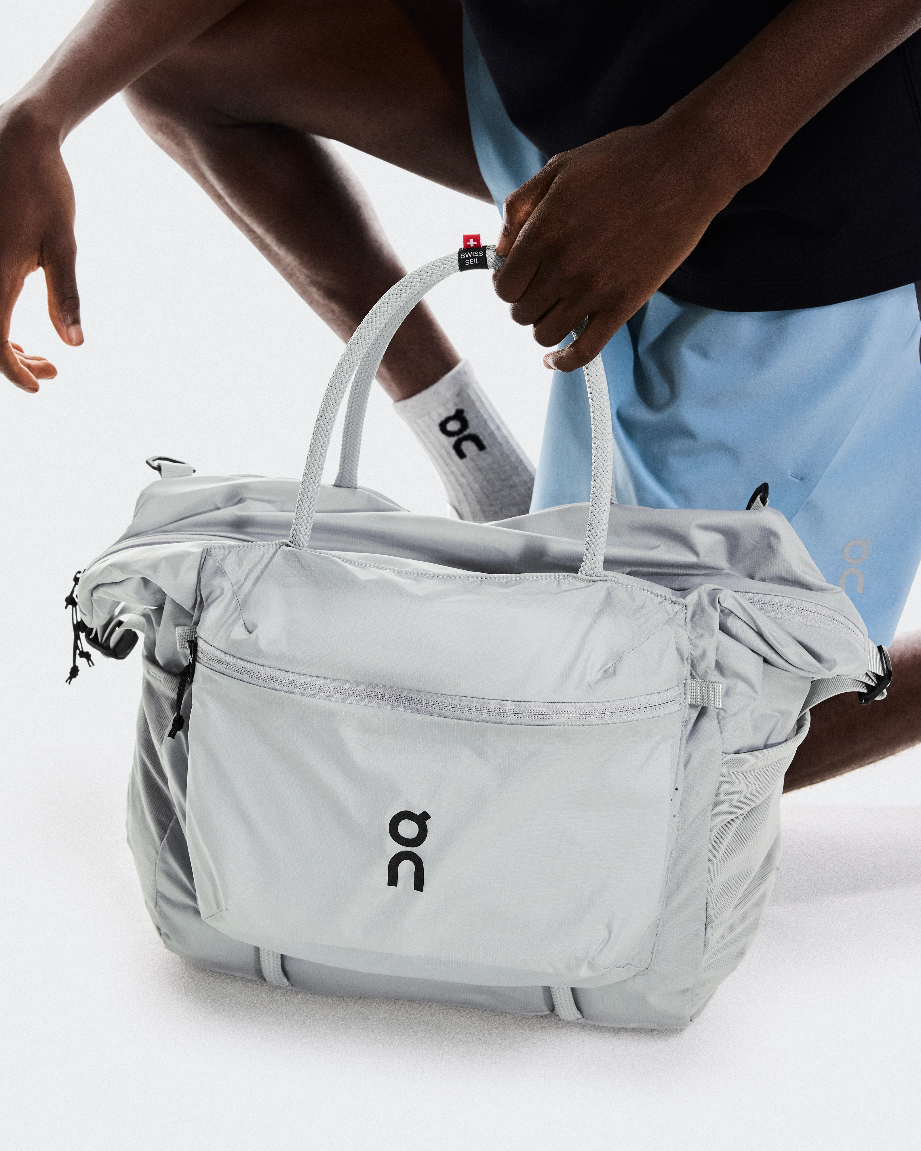 Une personne qui ramasse son sac de sport On.