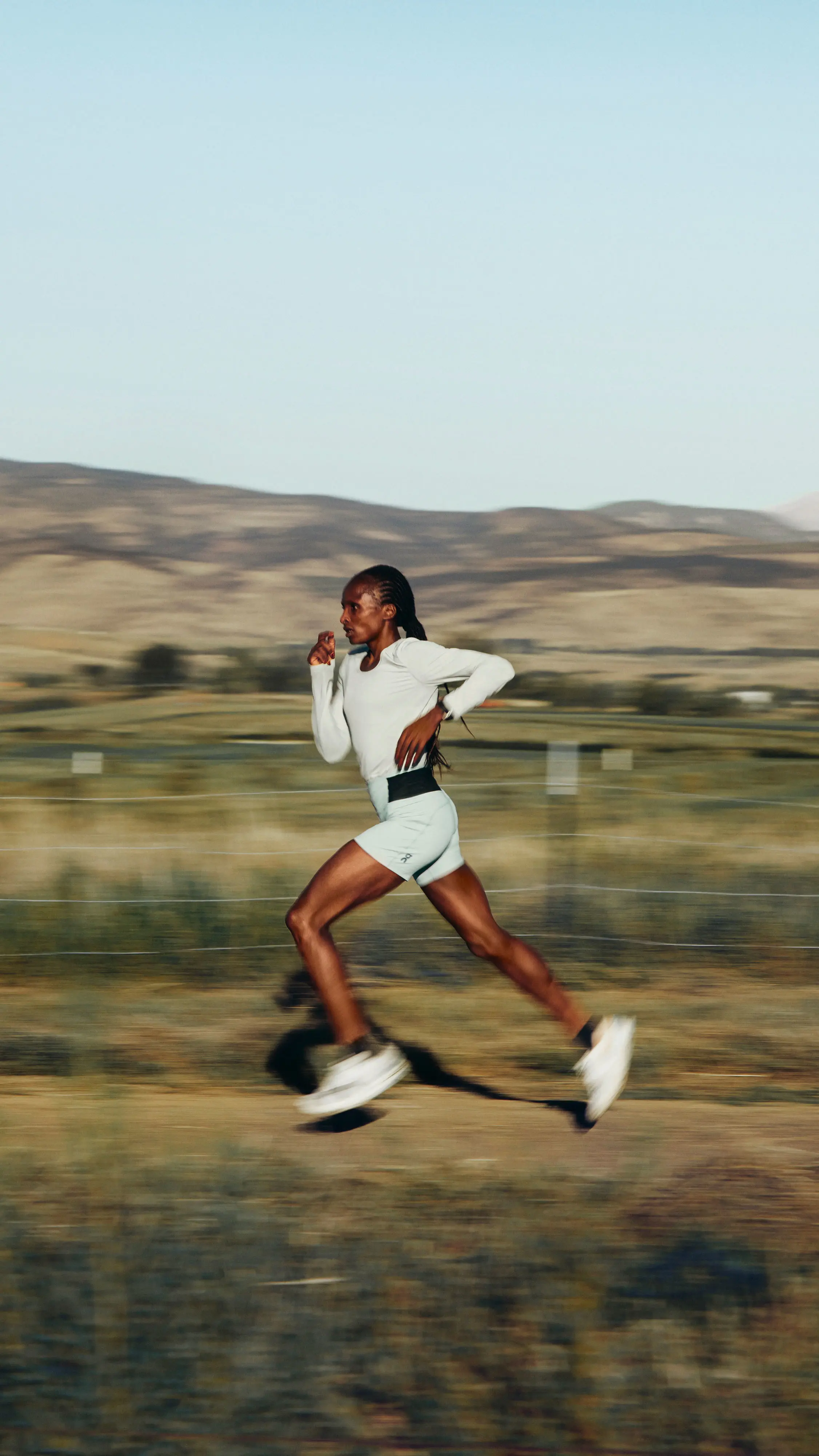 Hellen Obiri court au milieu d’un paysage montagneux.