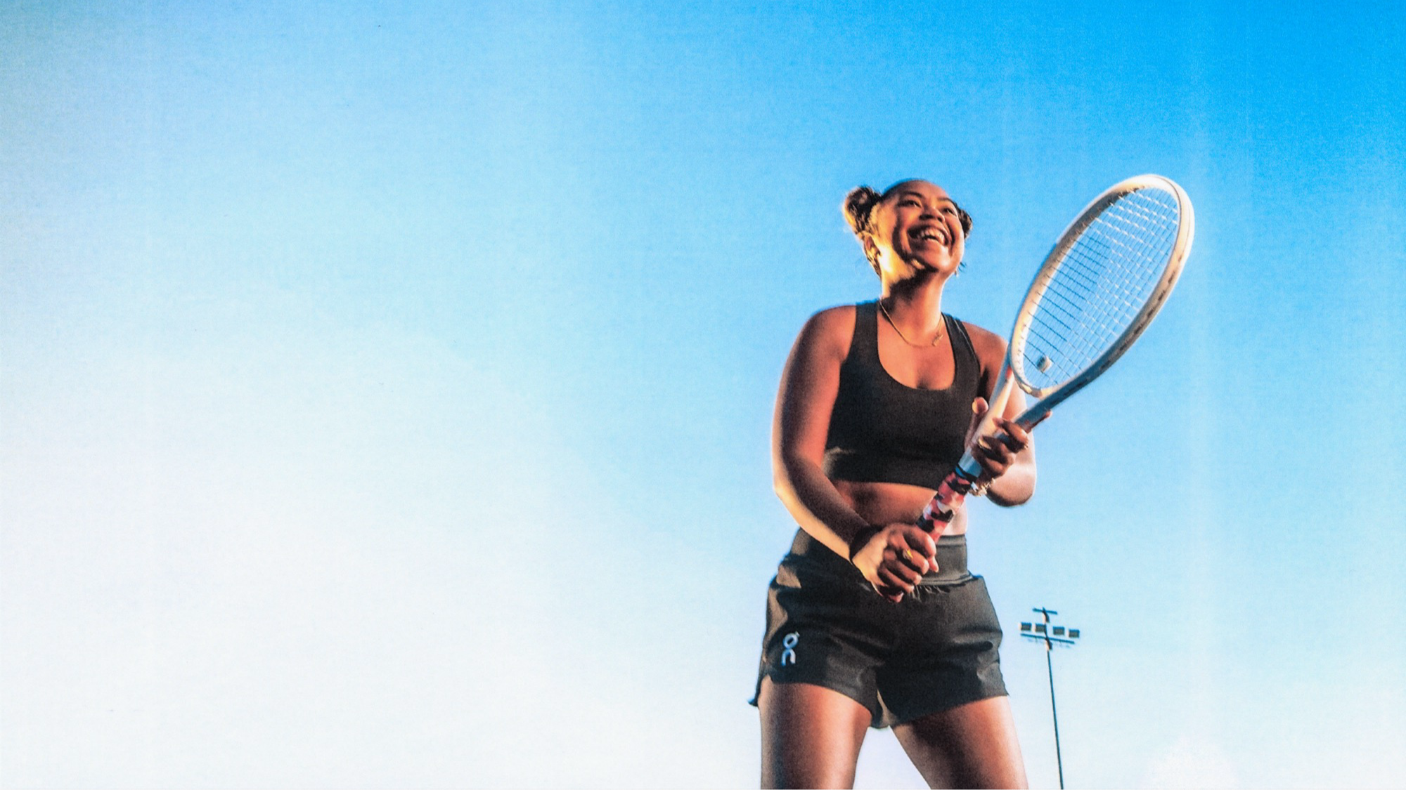 Une joueuse de tennis prend un moment pour apprécier sa performance et sourit en plein match.