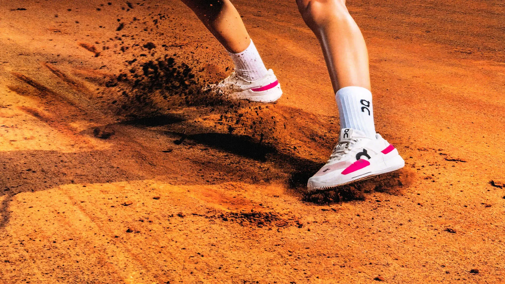 Une personne qui porte des chaussures de tennis glisse sur un court de tennis dur de couleur bleue.