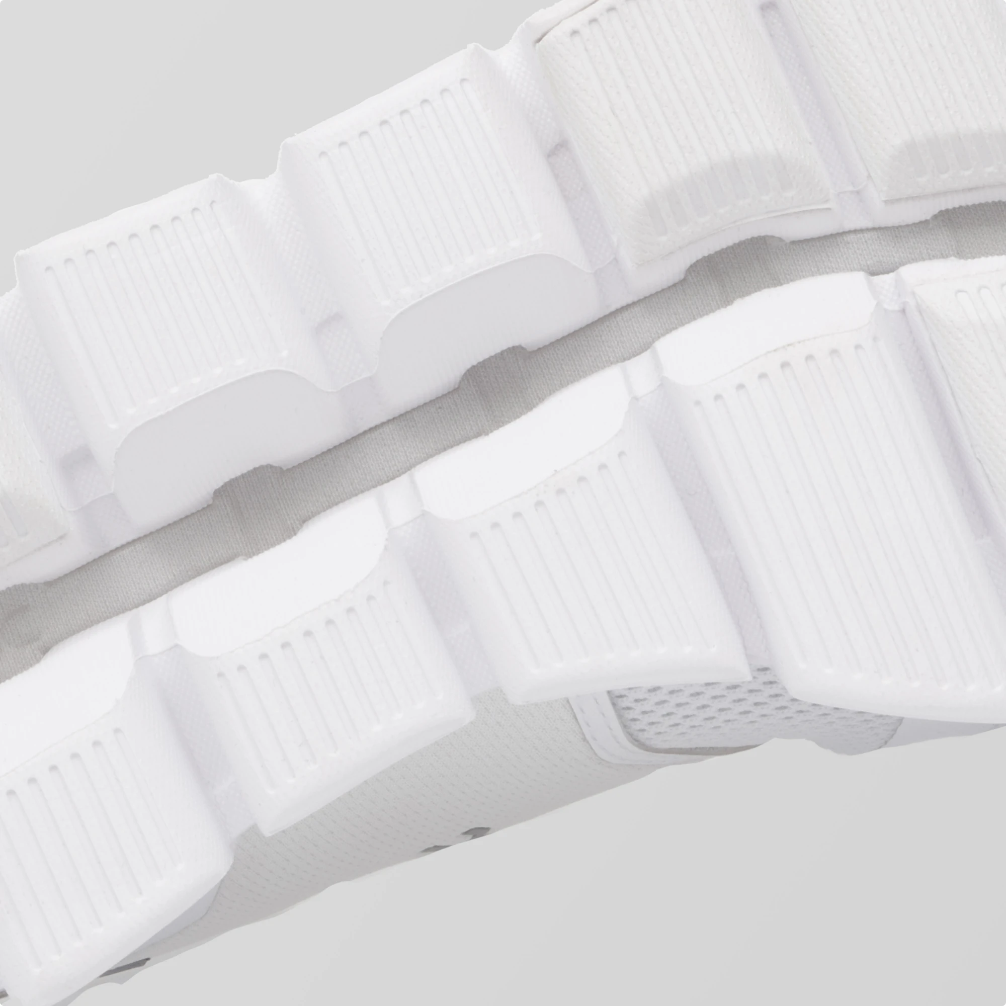 Gros plan sur une semelle extérieure CloudTec® blanche sur un fond gris. 