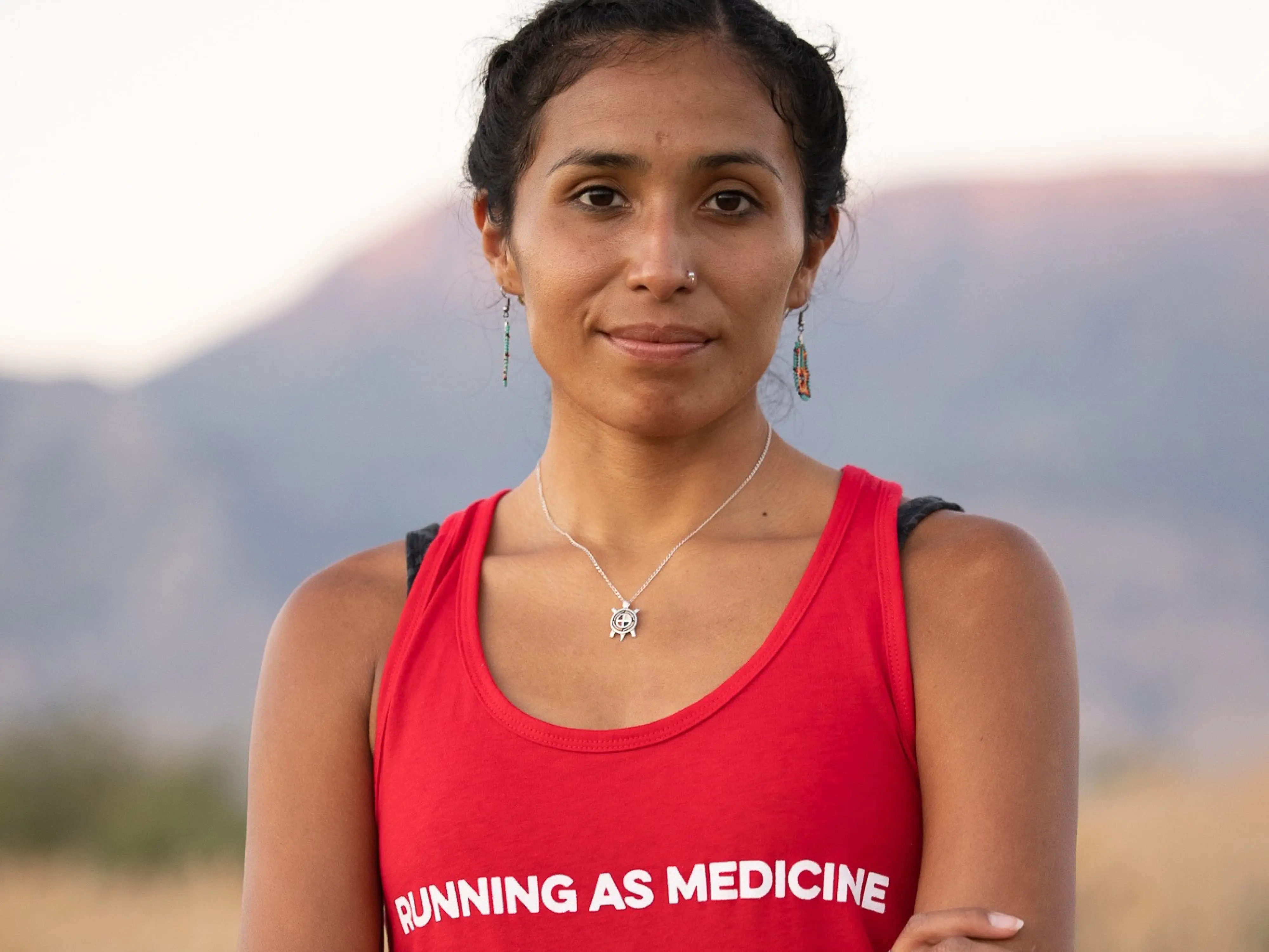 femme indigène face à l’objectif porte un t-shirt où est inscrit, running as medicine