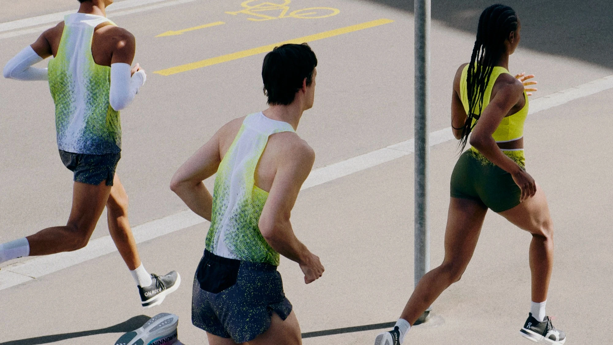 Trois runners en tenue On en train de courir sur le bitume.