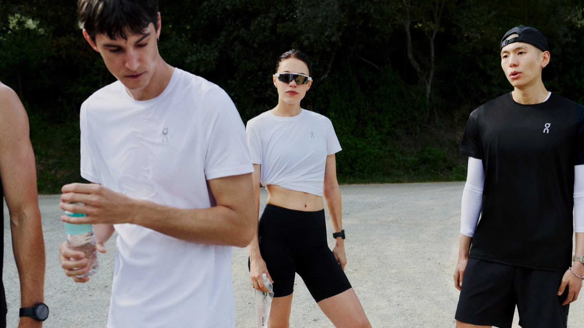 Un groupe de runners en pause, bouteilles d’eau en main.