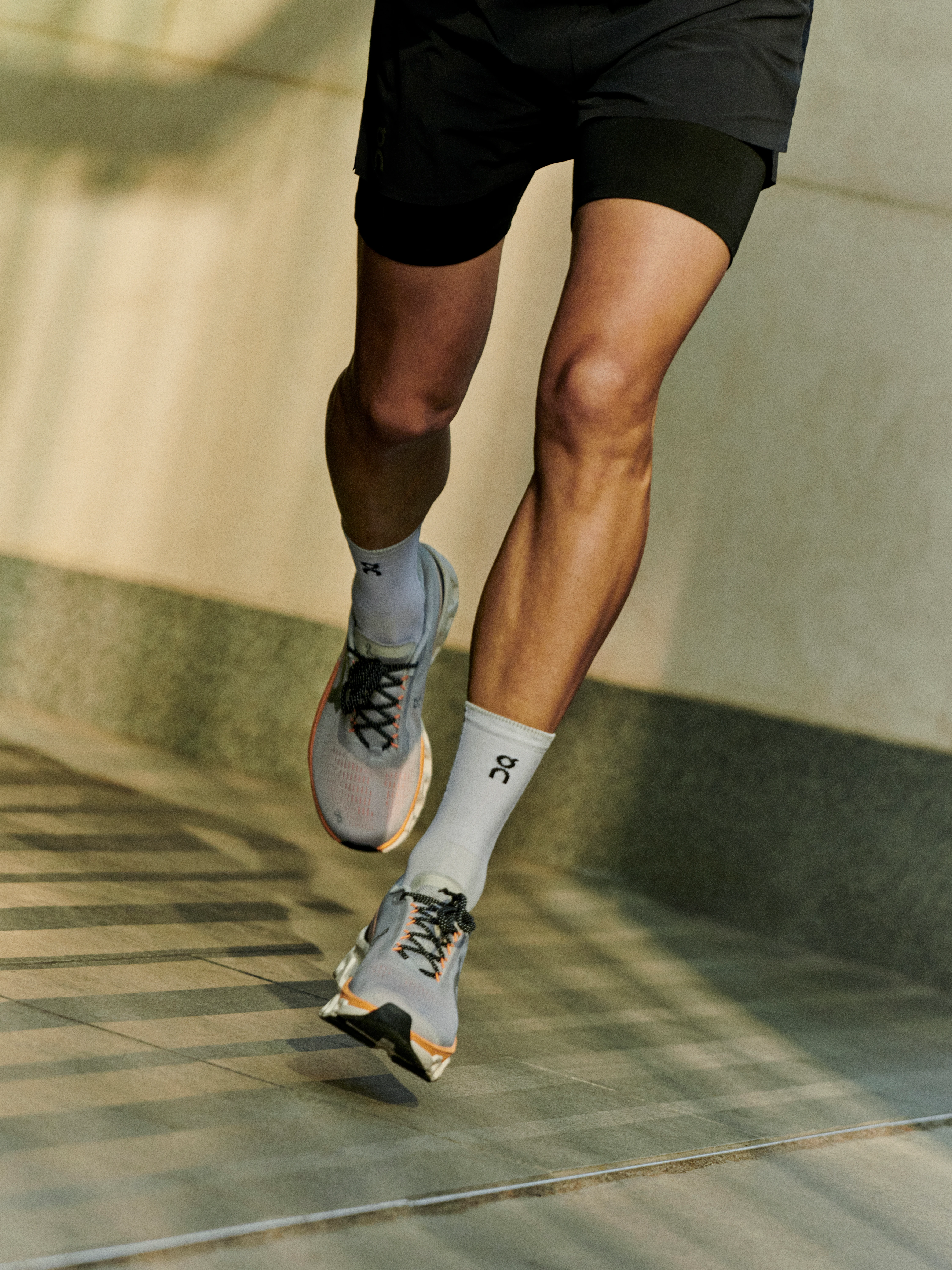 A runner in On gear from the front, mid-stride.