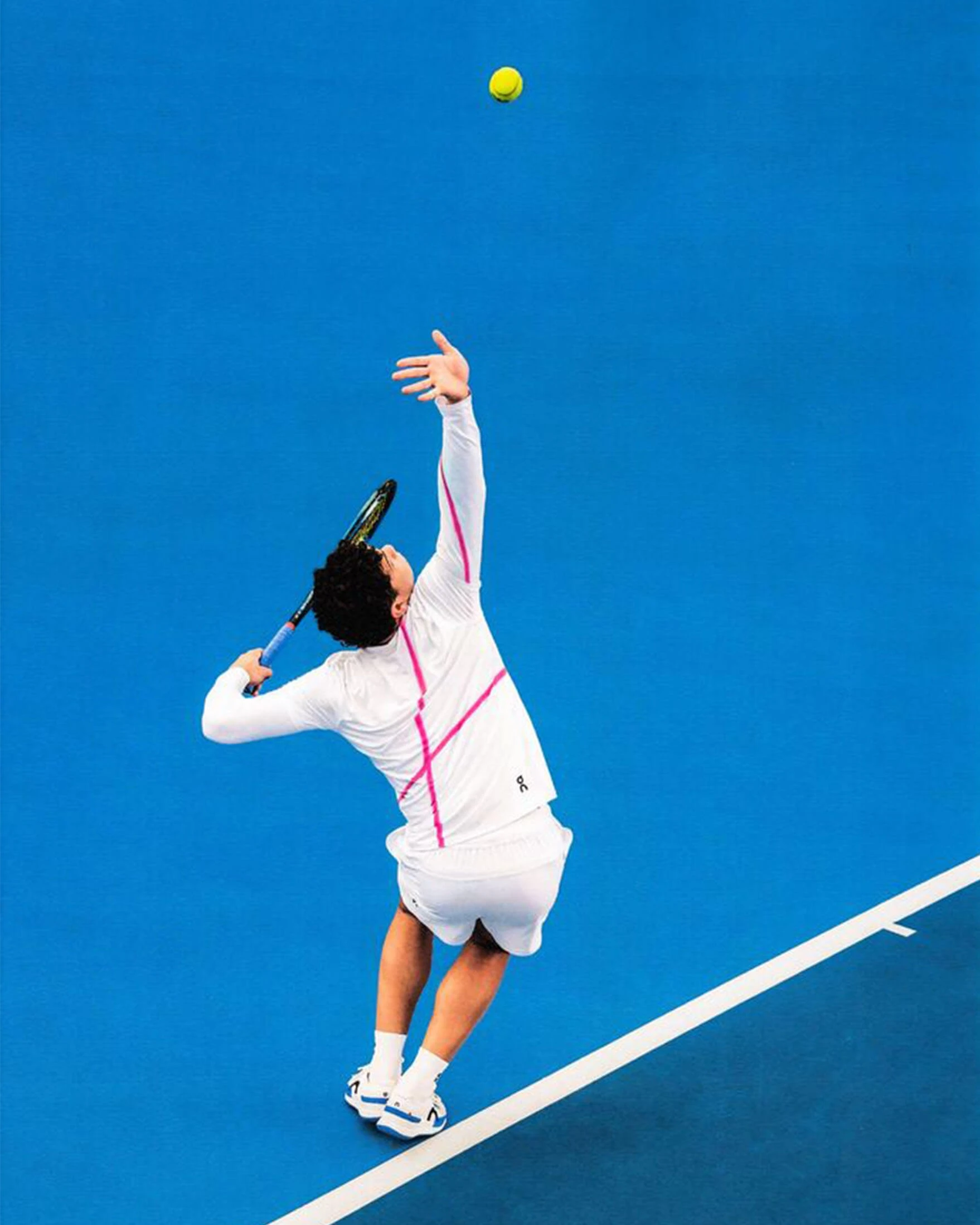 Ben Shelton se prépare à servir en lançant la balle de tennis en l’air.