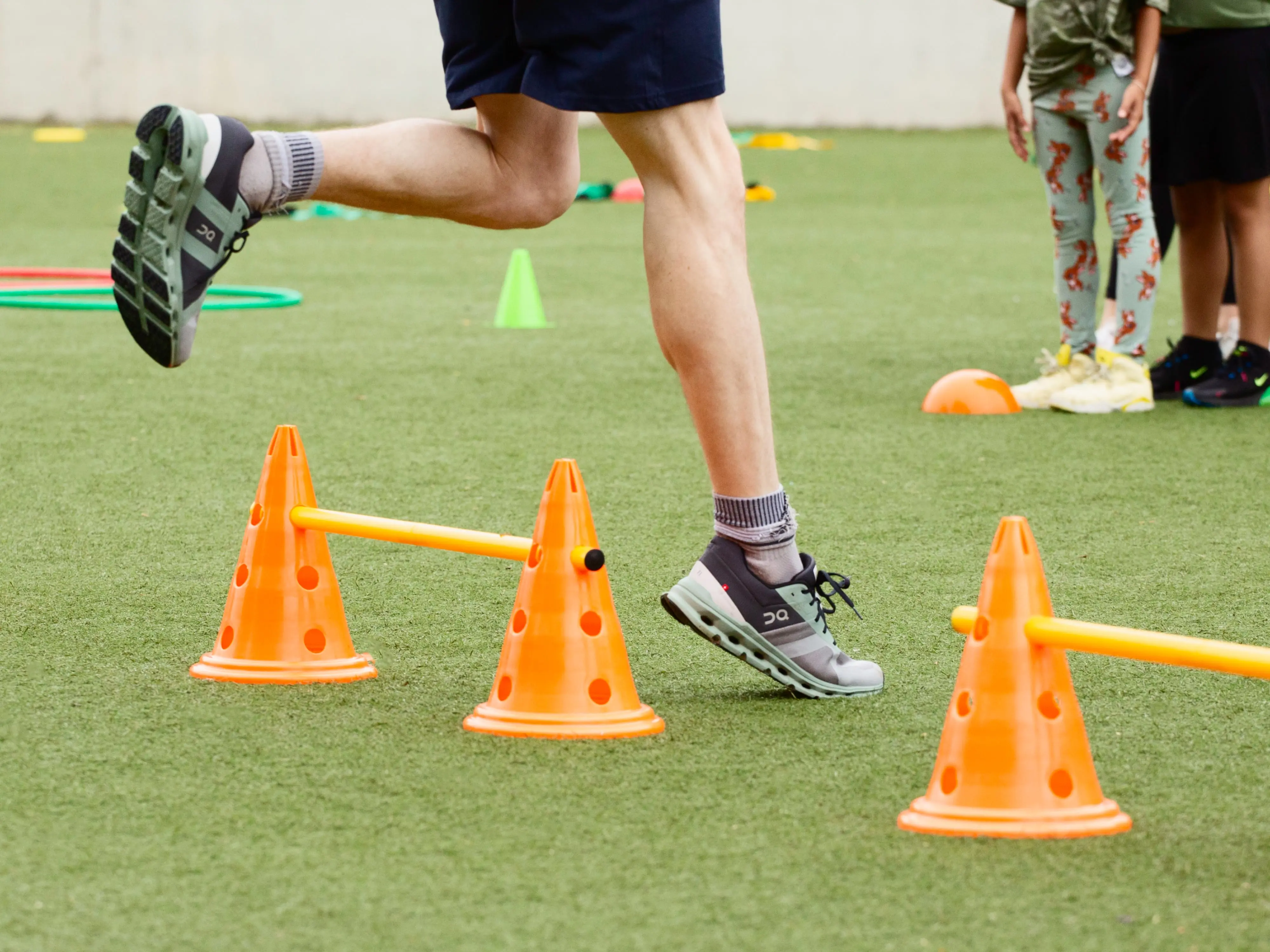gros plan sur des personnes portant des chaussures On lors d’un cours d’agilité