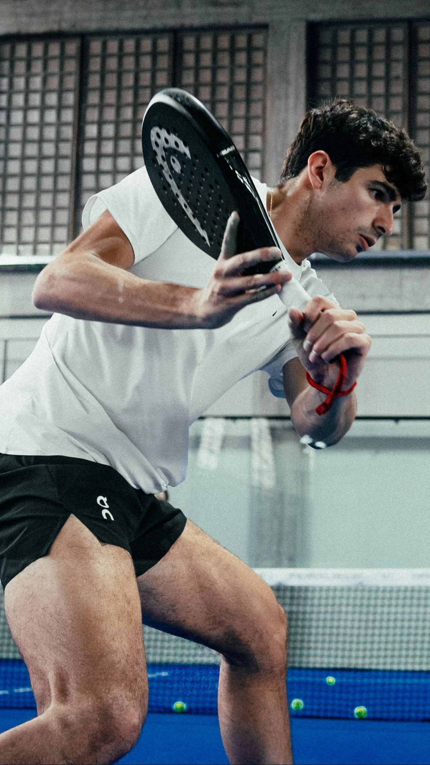 Un joueur de padel équipé de vêtements On frappe la balle avec sa raquette.