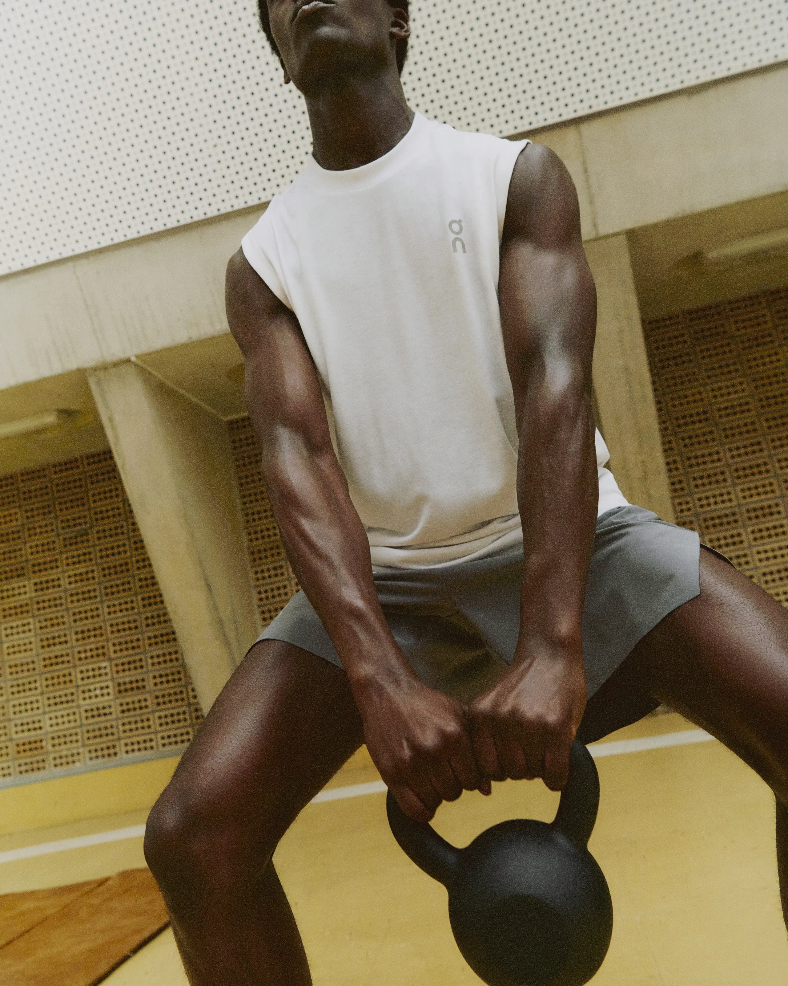 Un athlète en débardeur et short On soulève une kettlebell en salle.