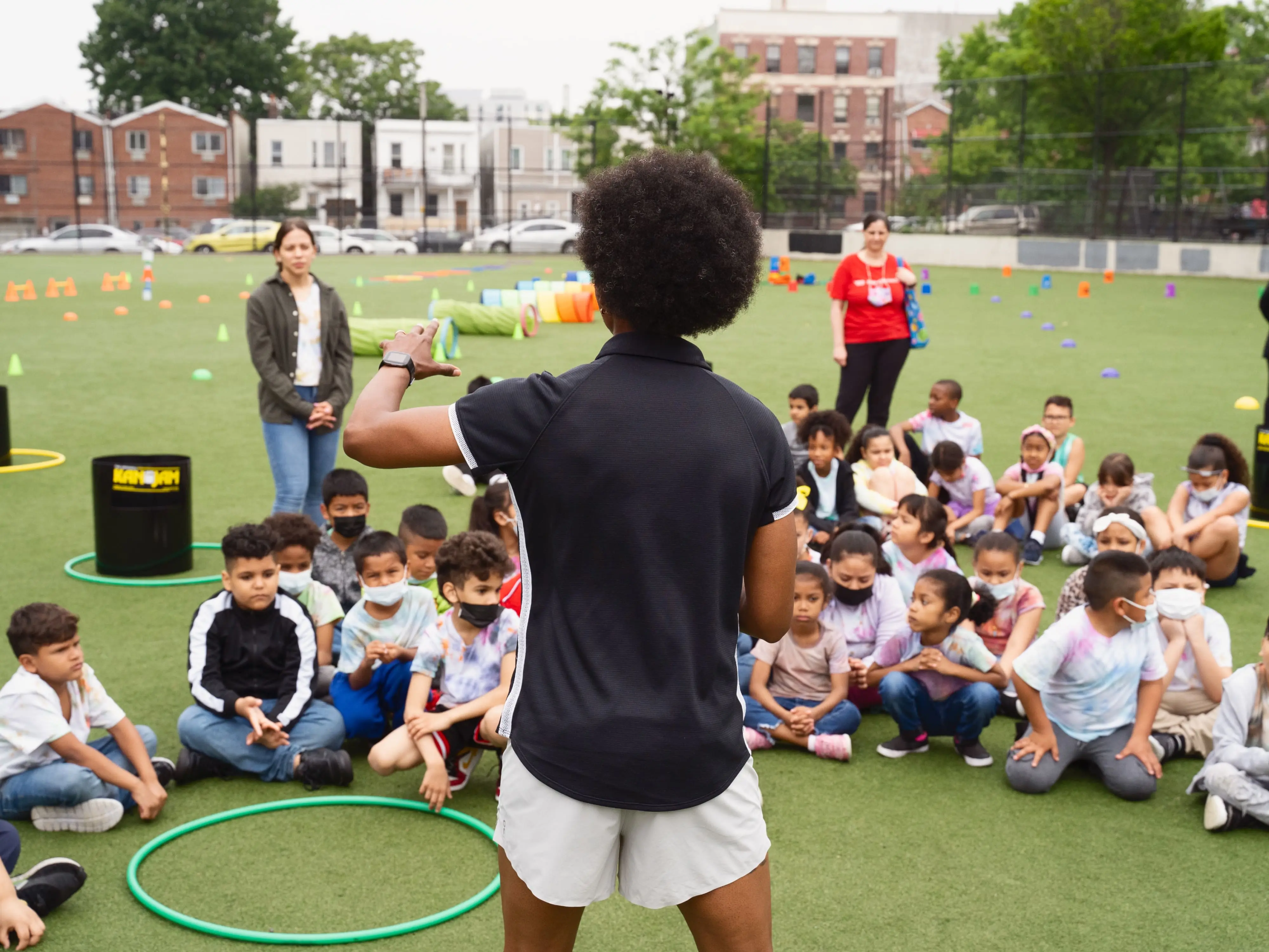 des coachs sportifs donnent des instructions à un groupe d’enfants